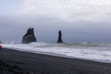 Reynisfjara kara plajı ve kayalar kışın Atlantik Okyanusu 'ndan yükseliyor.