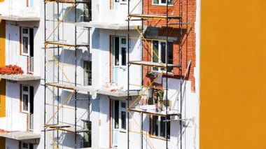 İskeledeki işçiler izolasyonu köpükle yalıtıyorlar.