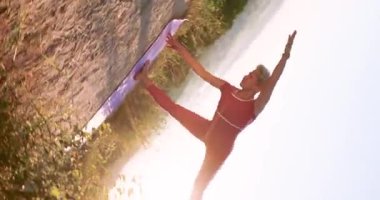 Kamera 360 'ı gösteriyor. Yetişkin bir yoga ustası poz veriyor. Yarım Ay Ardha Chandrasana işi ve gün doğumunda iki el üstünde duruyor.