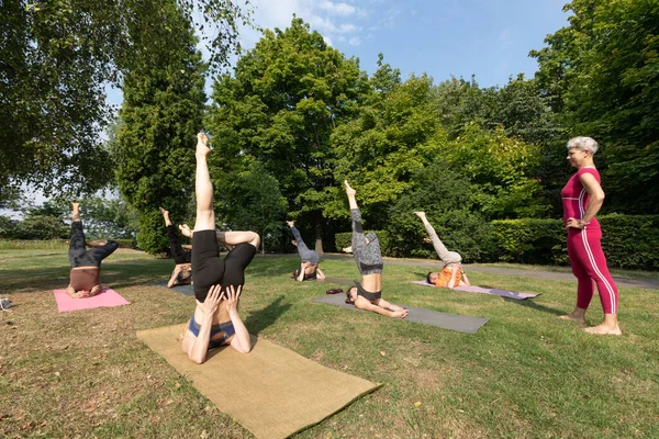 Yoga grubu esneme egzersizleri yapacak. Bir tanesi dışarıda kaldı.