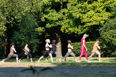 Şafak vakti, grup bir öğretmenin gözetiminde yoga yapıyor.