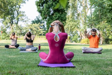 yoga öğretmeni meditasyon yapar ve Zen öğrencilerine Lotus pozisyonunda ve başlarının arkasında oturmayı öğretir.