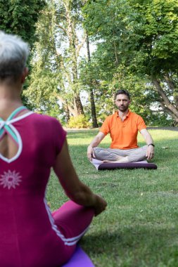 Lotus pozisyonunda bir adam çimenlerde oturup zen öğreniyor ve dinleniyor.
