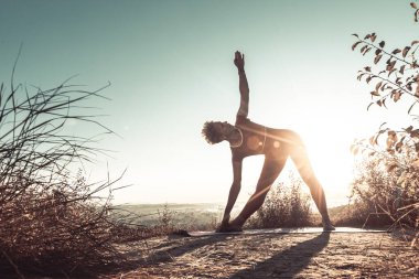 Emekliler gün doğumunda yoga egzersizleri yapıyor.