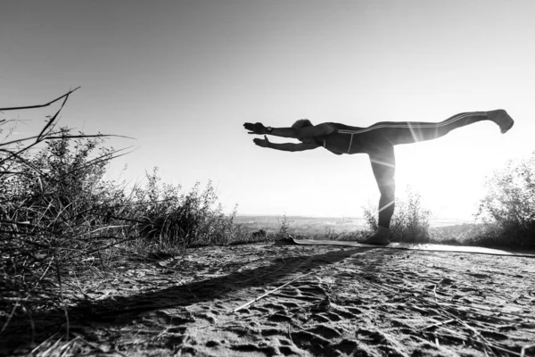 Black and White Silhouette Yoga master doing at sunrise exercise in position warrior