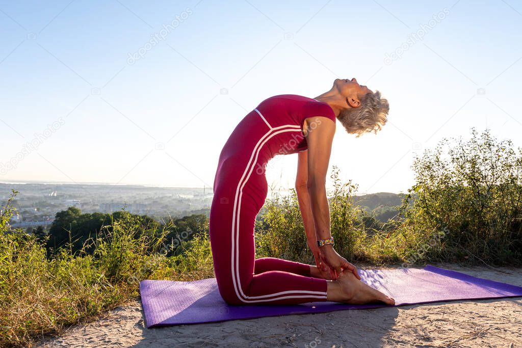 Woman at dawn sitting in a camel pose