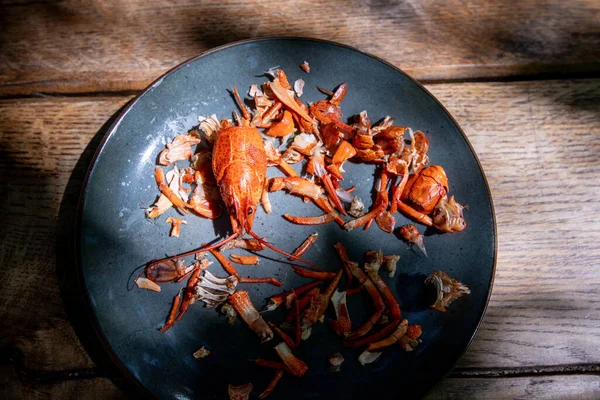 Yakın zamanda yenmiş bir bira bardağının yanındaki tabakta bulunan kerevit kalıntıları.