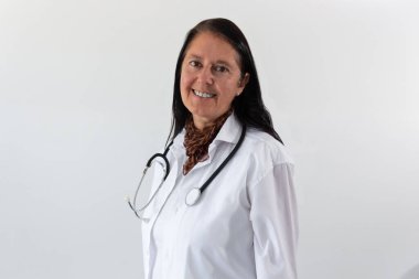 Beyaz önlüklü kadın doktor ve omuzlarında steteskopla gülümsüyor. Beyaz arkaplanda izole.