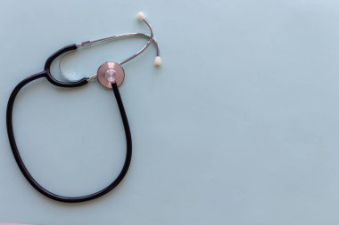 Açık mavi arka planda duran tıbbi steteskop düzlüğü. Sola hizalama.