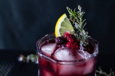 Böğürtlen, biberiye ve limondan yapılmış kokteyl garnitürü. Koyu arkaplan ile yakın plan çekim. 
