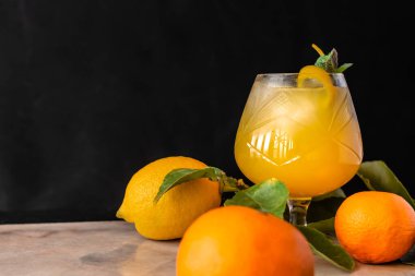 Naneli ve limonlu süslemeli bardakta mango ve portakallı yaz kokteyli. Koyu arkaplan. 