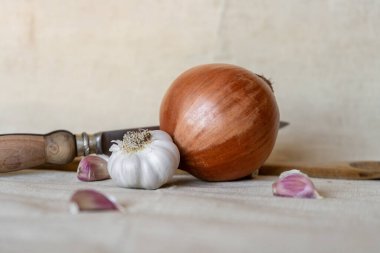 Yumuşak bej arka planda sarımsak ve soğan kompozisyonu.