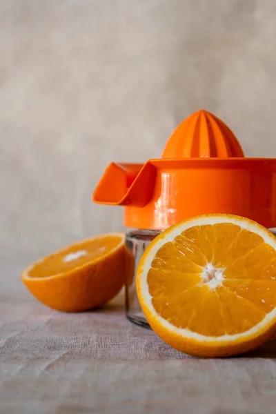 Vertical shot of manual juicer with jimmy oranges cut in halves