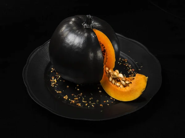 Siyah bir arka plan üzerinde siyah bir plaka üzerinde siyah kabak.