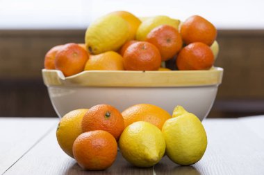 meyve narenciye dolu ve sanki onlar katılmadı ön tarafta bulunan bazı muz, iki limon, iki portakal ve iki mandalina kase