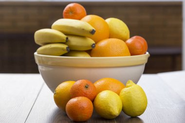 meyve narenciye dolu ve sanki onlar katılmadı ön tarafta bulunan bazı muz, iki limon, iki portakal ve iki mandalina kase