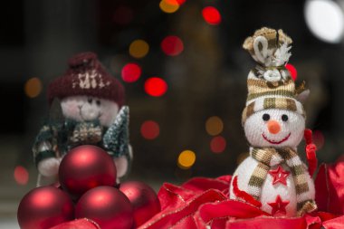 Kırmızı topları, kardan adam, kırmızı kurdele ve renkli ışıklar Noel kompozisyonu