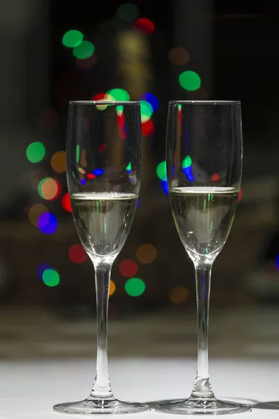 Twee Glazen Van Champagne Achtergrond Verlichting Van Typische Kerst Kleuren — Stockfoto