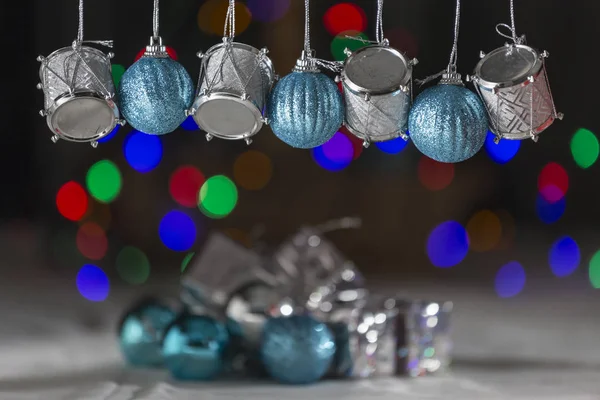 圣诞饰品 银鼓和蓝球 挂在酒吧 在背景彩色光盘 当圣诞树的灯光失去焦点 — 图库照片