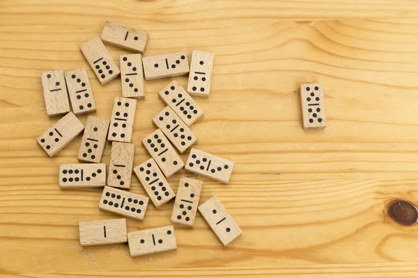 wooden domino tokens scattered on a surface also made of wood