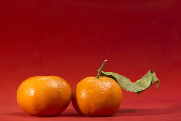 Ansicht Von Zwei Mandarinen Auf Rotem Hintergrund Eine Mit Grünem — Stockfoto