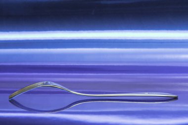 Metalik mavi yüzey üzerinde dinlenmek için gibi görünüyor bir çatal görünümünü