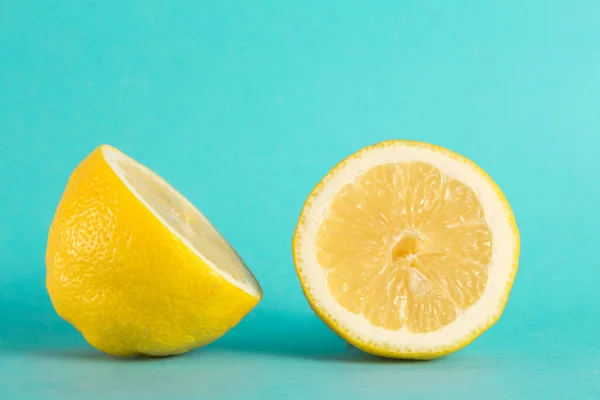 lemon cut in half, shows us its front and back sides, the image is on a blue background