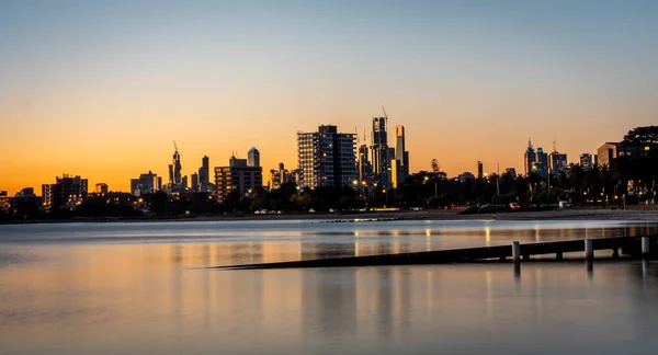 long exposure photography with reflections in still water. The reflections of the melbourne city skyline at dusk in the still water of albert park lake