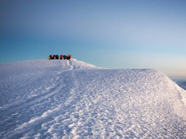 Bulutların üzerinde şafak sökerken, kili ve meru dağları Tanzanya Serengiti 'sinde. Yürüyüşçüler Afrika 'nın en yüksek dağının zirvesine doğru yol alıyorlar.