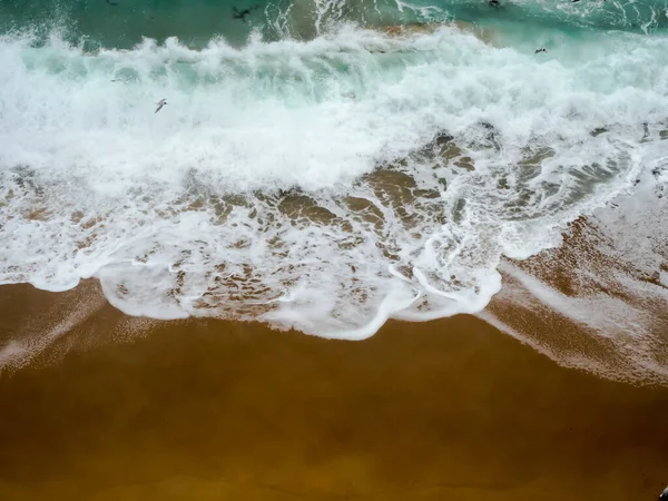 Massive waves in stormy melbourne weather crashing along the sandstone beach near the twelve apostles in melbourne victoria australia