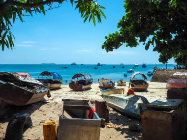 Zanzibar adasındaki taştan kasabada balıkçı tekneleri ve kristal berrak turkuaz sular..