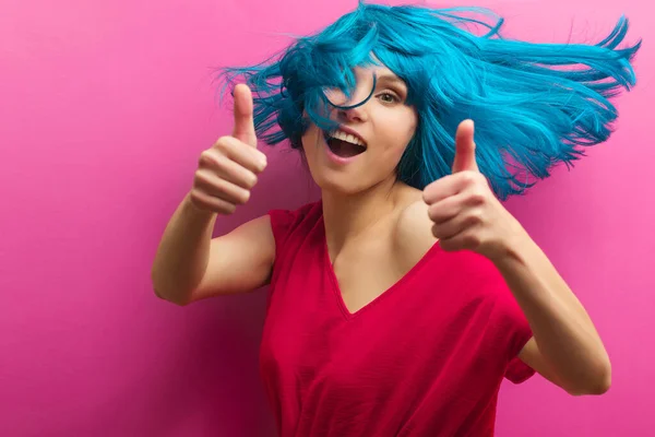 Retrato de estudio de una hermosa chica sexy con una sonrisa en movimiento sobre un fondo rosa. Chica con el pelo azul — Foto de Stock