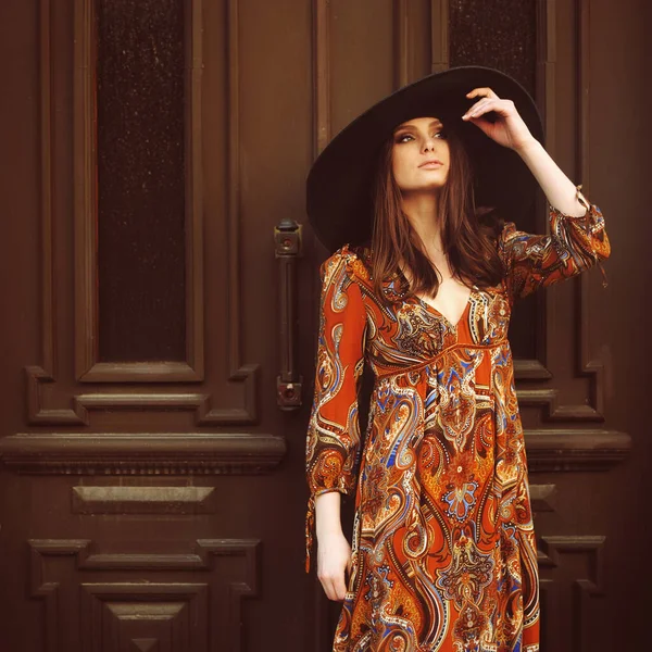 Egy gyönyörű lány portréja kalapos ruhában az ajtóban. Stock Kép
