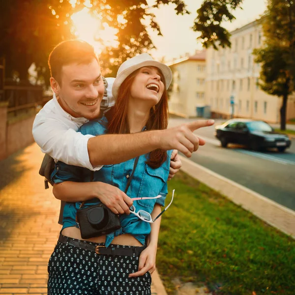 Fiatal, mosolygós, boldog európai pár a város napfényes utcájában Stock Fotó