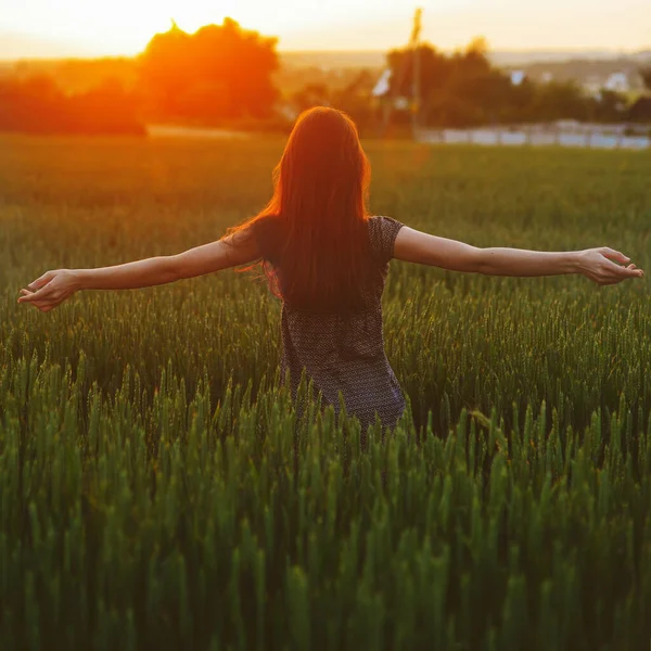 Porträt eines Mädchens, das sich bei Sonnenuntergang im Feld entspannt — Stockfoto