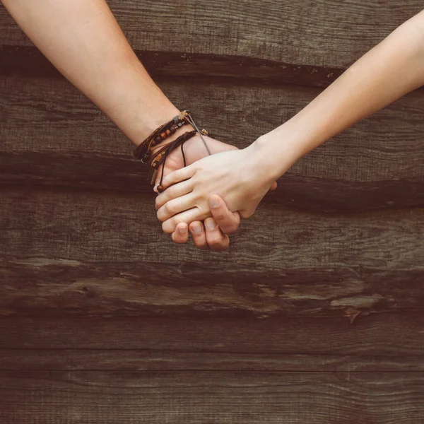 Egy szerető pár kezei fából készült háttéren Stock Kép