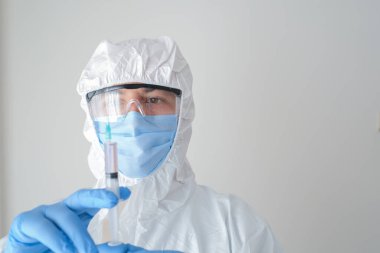 Elinde şırıngayla korunan bir doktor. Genç doktor aşıya hazırlanıyor..