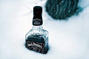 Kyiv, Ukrayna - 1 Ocak 2011: Jack Daniel 'in viski şişesi kardan sarkıyor, arka planda ağaç