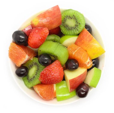 Beyaz arka planda bir kase sağlıklı taze meyve salatası. Üst görünüm.