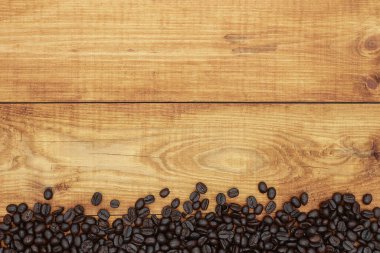 Ahşap arka planda kahve çekirdekleri Üst görünüm ve boşluk kopyala