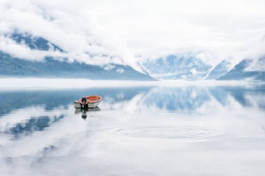 Fiyortlu, botlu ve bulutlu güzel manzara sulara, Norveç 'e yansıyor.