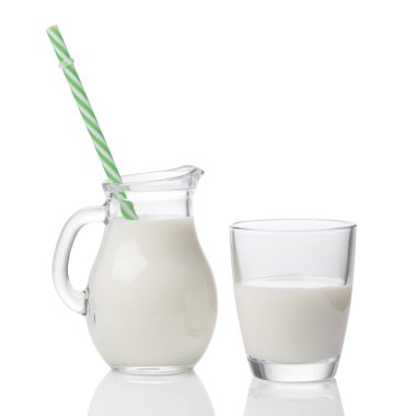 Beyaz arka planda saman izole edilmiş bir bardak ve sürahi süt.