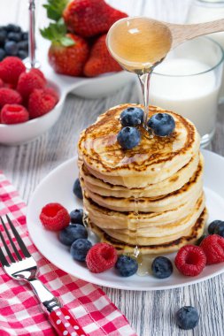 Taze yaban mersinli ve ahududulu krep, bal ile doldurulmuş. Süt ve taze böğürtlen, sağlıklı kahvaltı kavramı