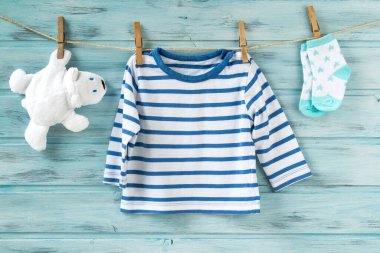 Çizgili gömlek, yıldızlı çorap ve çamaşır ipinde beyaz oyuncak ayı.