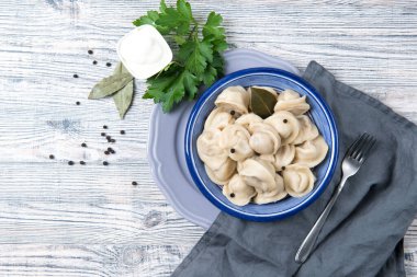 Geleneksel pelmeni, ravioli, ahşap arka planda etle doldurulmuş hamur tatlısı, Rus mutfağı manzarası.