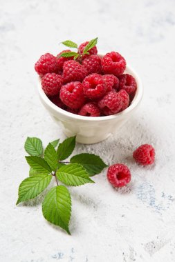 Taze ahududu ve taş bir masada yapraklar, üst manzara.