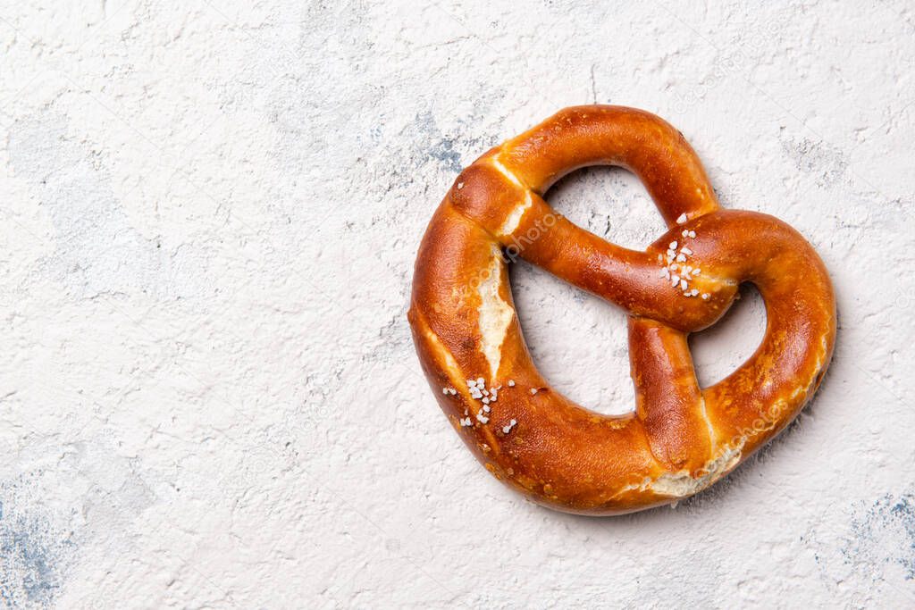 Fresh backed pretzel on a stone table, beer snack, top view with copy space