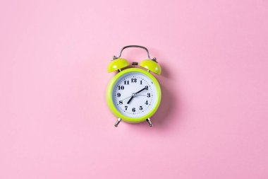 Pembe zili olan yeşil alarm saati, kopyalama alanı olan üst görünüm