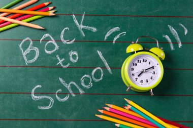 Tahtadaki alarm saati ve renkli kalemler okul metnine, üst görünüme geri dönüyor.