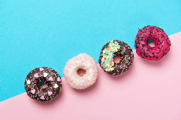 Різнокольорові Пончики Поспіль Мінімалізм Синьо Рожевому Тлі Вид Зверху — стокове фото